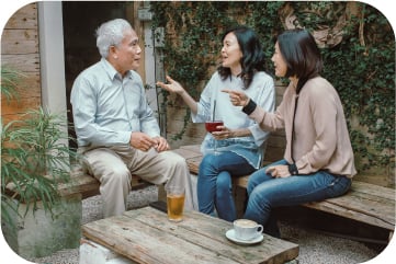 屋外で談笑している多世代のグループ